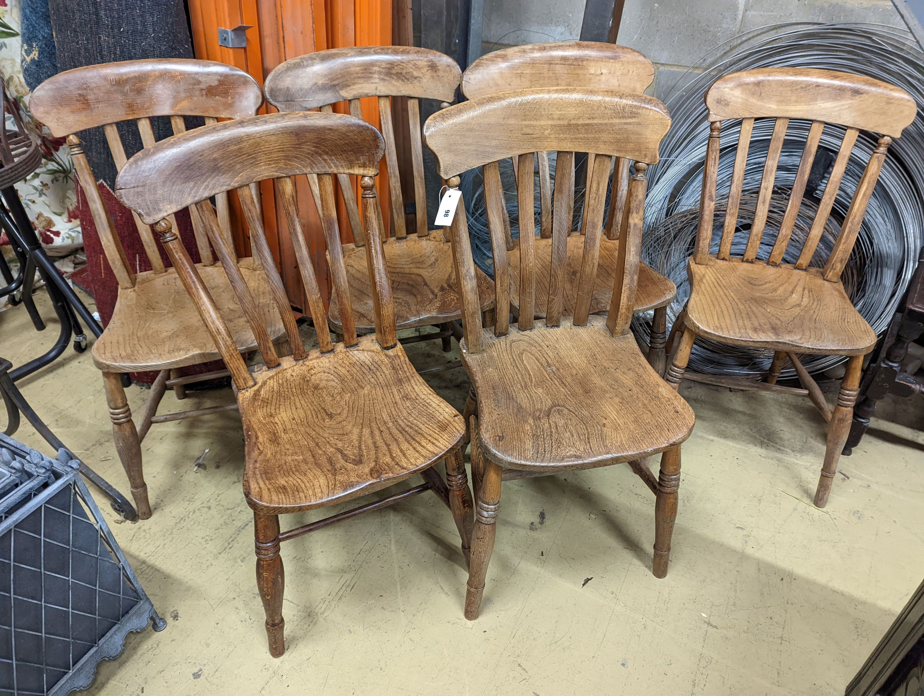A harlequin set of six Victorian elm and beech Windsor lathe back kitchen chairs